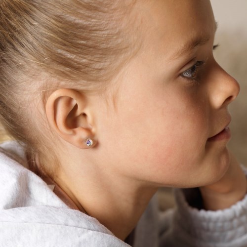 En ung jente med blond hår, iført svart og hvit, sett fra siden.