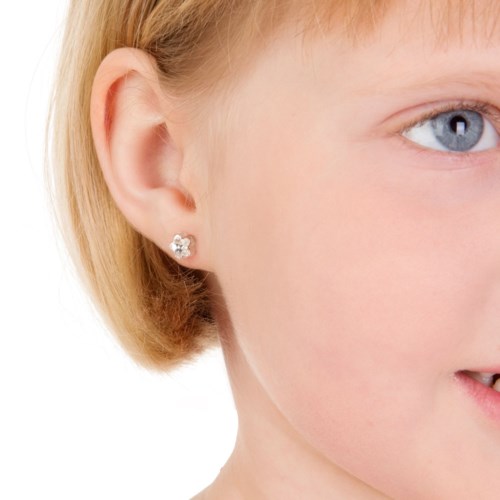 Close-up of a young girl with blonde hair, wearing a small butterfly-shaped earring on her ear.