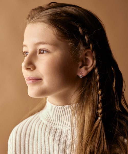 A girl with long, light brown hair and braid, wearing a cream-colored sweater, looking to the side.