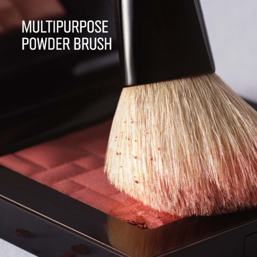 En sminkbørste som påfører rouge på et kompakt pudder. Børsten er merket multipurpose powder brush.