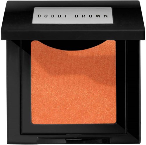 A compact Bobbi Brown makeup product with orange-colored shimmer powder inside.