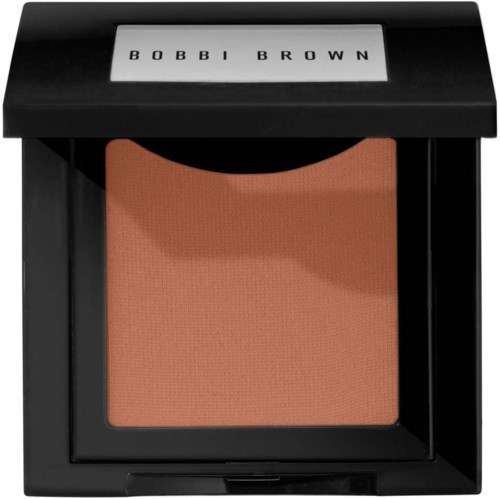 A compact with a large peach-colored blush inside and a black case with "BOBBI BROWN" written on the lid.