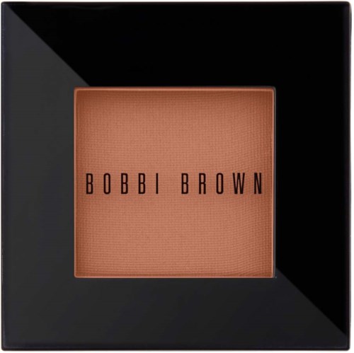 A square Bobbi Brown makeup product in a black box, showing a peachy-bink shade inside.