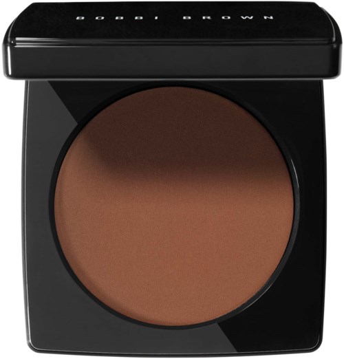 En rund sminkkompakt med svart lock, innehållande brunt pressat puder inuti. Locket har 'BOBBI BROWN' skrivet på sig.