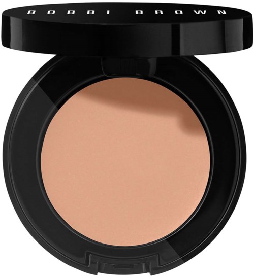 A round compact with beige face powder and a black lid labeled 'BOBBI BROWN.'