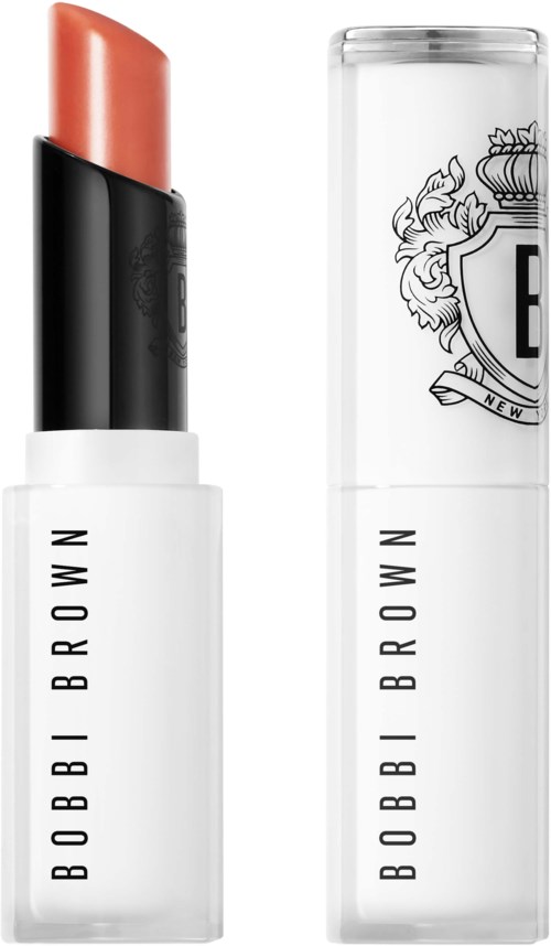 A lipstick in a black and white case with the brand name Bobbi Brown. The lipstick is light peach in color.