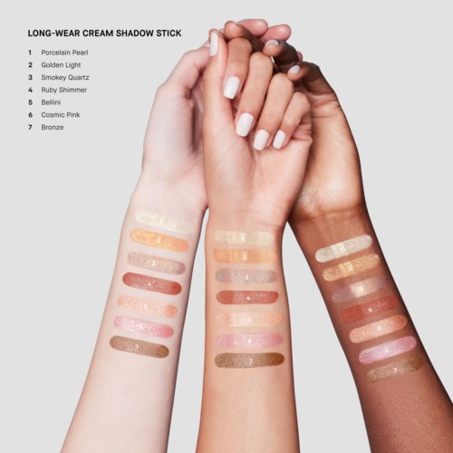 Three hands show swatches of makeup shades labeled with different names on forearms.