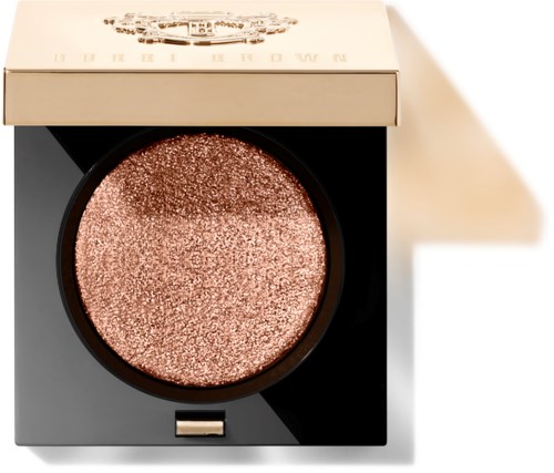A round, shimmery rose-colored makeup product in a black and white box.