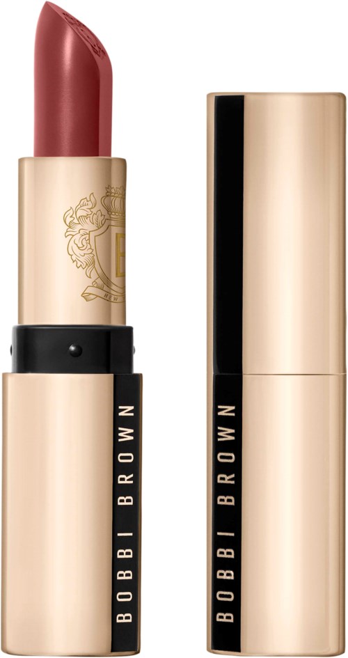 A lipstick with a gold case and black accents, showing the lipstick partially twisted up. The case has a brand logo.