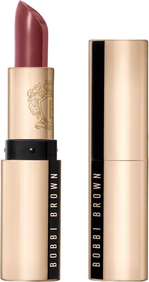 A Barbie doll lipstick with a gold and black case, showing the lipstick shade inside.