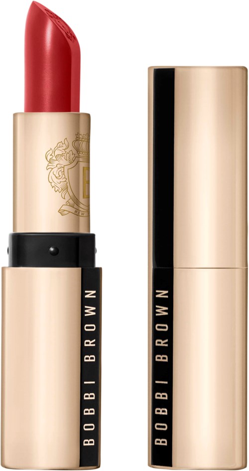 A red lipstick in a gold and black tube, with the lid off showing the lipstick. The tube has "BOBBI BROWN" written on it.