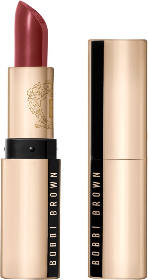 A lipstick with a gold and black case, showing a red color and a decorative logo on the gold part.
