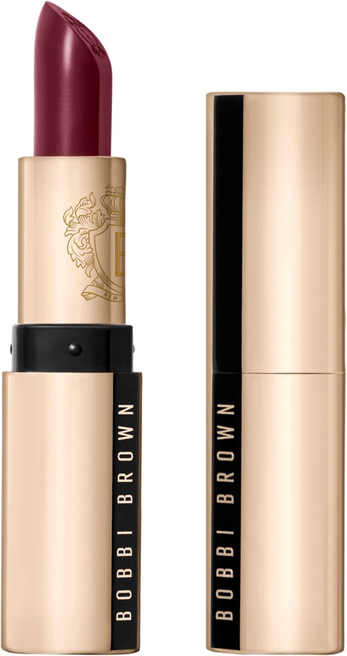 A red lipstick in a gold and black tube, with a matching gold cap, displayed upright.