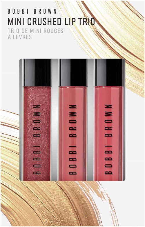Tre Bobbi Brown mini crushed läppglans i rosa nyanser med svarta lock, visas på vit bakgrund medguld accenter.