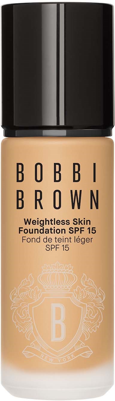 A foundation bottle with black cap, beige liquid, and a shield logo with B on it.