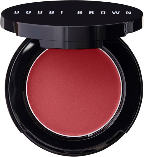 Ein runder Compact mit roten Rouge innen und einem schwarzen Deckel mit weißem Text.