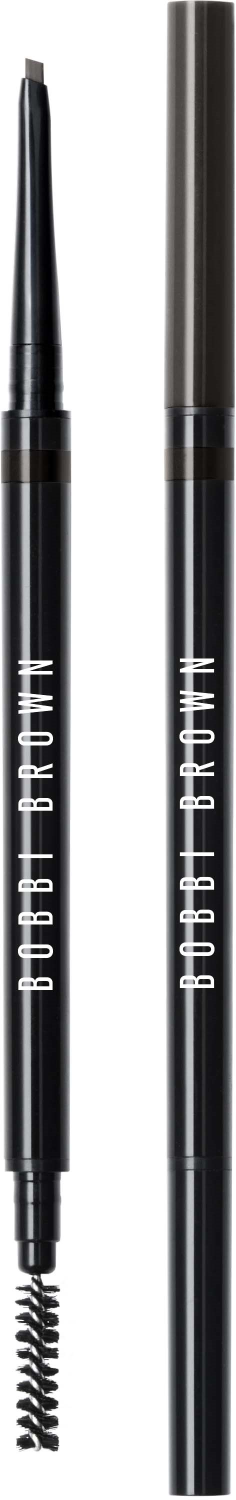 Two black eyebrow pencils, one with a spoolie brush, stand upright against a black background.