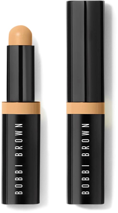 A Bobbi Brown makeup stick with a beige product inside, and a black and beige packaging. Both are opened.