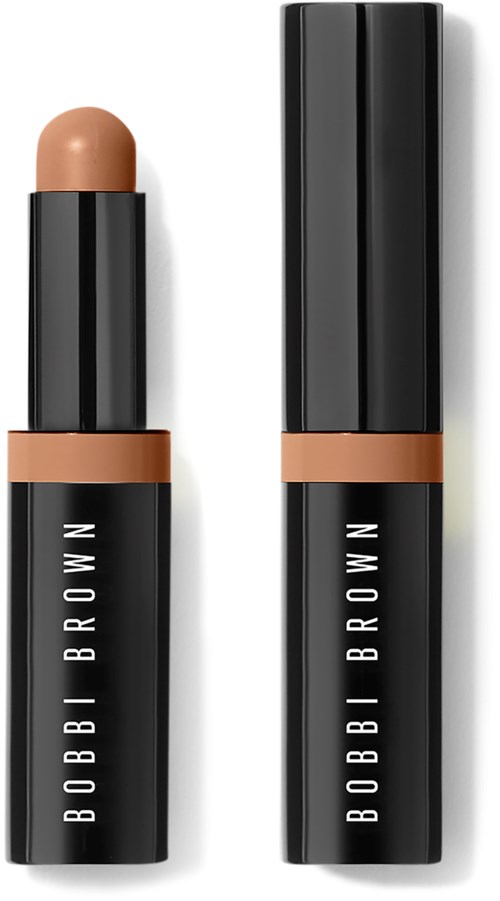 A black lipstick tube with a partially opened cap, showing beige lipstick. The product name is Bobbi Brown.