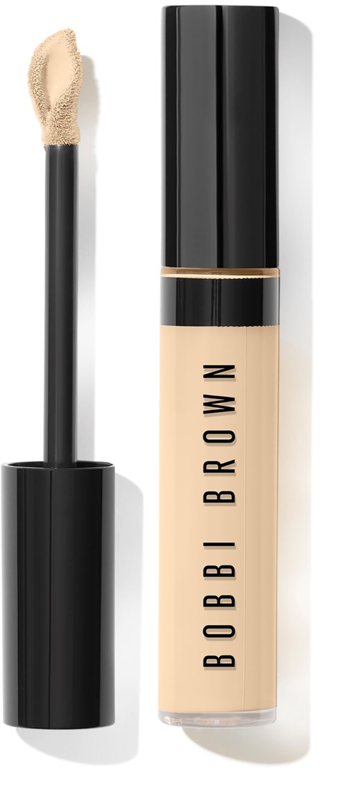 Bobbi Brown nestemäinen peiteaineputki mustalla korkilla, läpinäkyvä runko, jossa näkyy beigen sävyinen tuote, ja sienen sovitin.