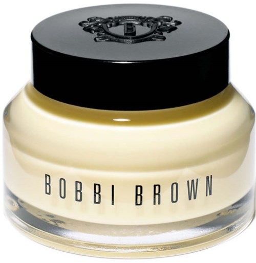 A round cream-colored jar with a black lid featuring a decorative crest and the label 'BOBBI BROWN' in black.