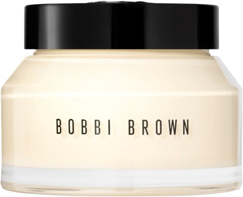 En liten burk med svart lock, märkt 'Bobbi Brown', innehåller en kosmetisk produkt, möjligen kräm eller foundation.