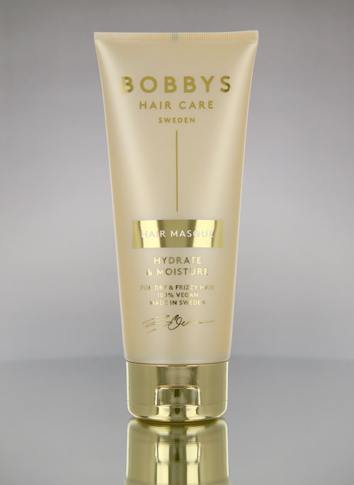 Eine gelbe Tube mit Bobby's Hair Care, Schweden, für Haarmasken, Hydratation und Feuchtigkeit, mit goldener Kappe.