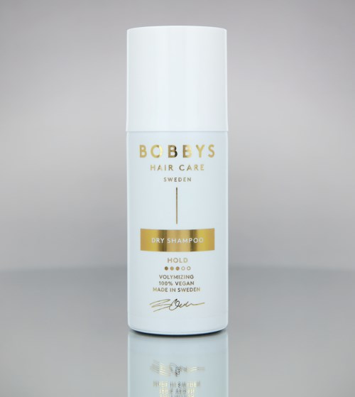 Een witte fles met Bobby's Hair Care, Dry Shampoo, hold, vegan, gemaakt in Zweden, simpel ontwerp.