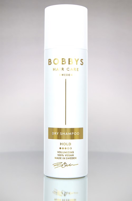 Eine weiße Flasche Trockenshampoo, beschriftet mit 'Bobby's Hair Care Sweden' in Gold- und Schwarztext und schlichtem Design.