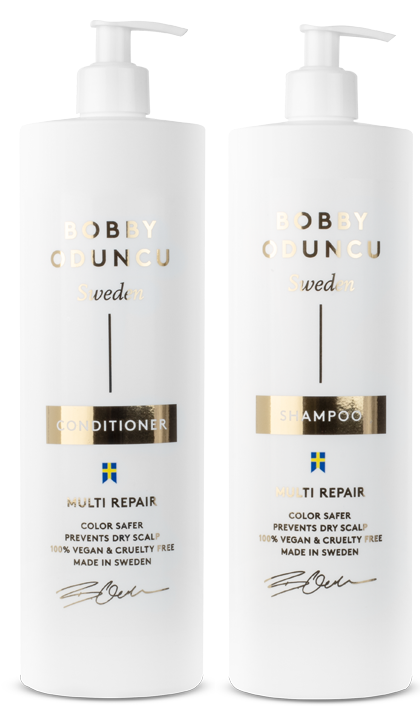 Zwei weiße Flaschen mit Haarpflegeprodukten, eine für Shampoo und eine für Conditioner, mit goldenen und schwarzen Etiketten, nebeneinander.