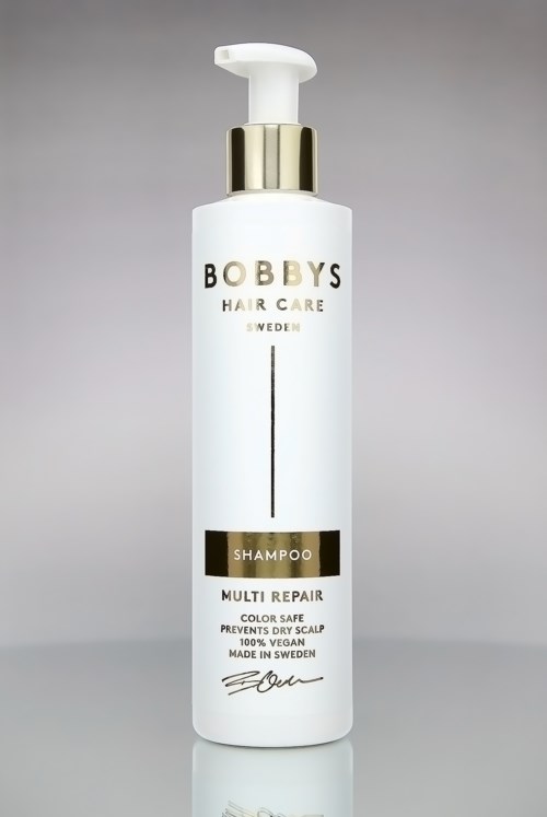 Eine weiße Shampooflasche mit goldenen und schwarzen Akzenten, beschriftet mit 'Bobby's Hair Care Sweden' und 'Multi Repair'.