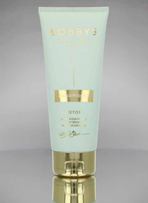 Eine hellgrüne Flasche mit goldenen Akzenten, Beschriftung 'Bobby's Hair Care' und 'Conditioner' für Haargesundheit und Detox.
