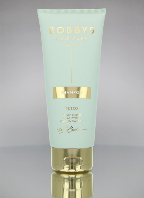 Eine hellgrüne Flasche mit Bobby's Hair Care Detox-Shampoo, goldenen Akzenten und schlichter Schrift.