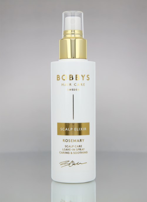 A white bottle with a gold cap and spray top, labeled 'Bobby's Place Rosemary Scalp Elixir' for hair care.