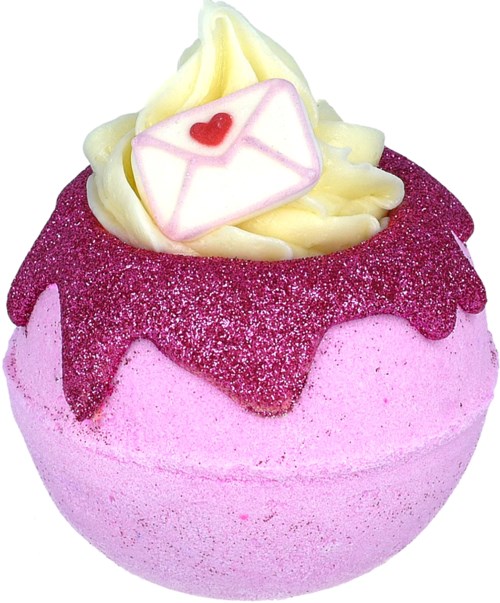 Een roze badbommetje met paarse glitter, bedekt met room en een kleine envelop met hartdecoratie.