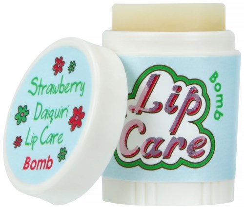 Een klein witte container met lippenbalsem, kleurrijke tekst en bloemillustraties, gemarkeerd "Lip Care," naast een ronde deksel.