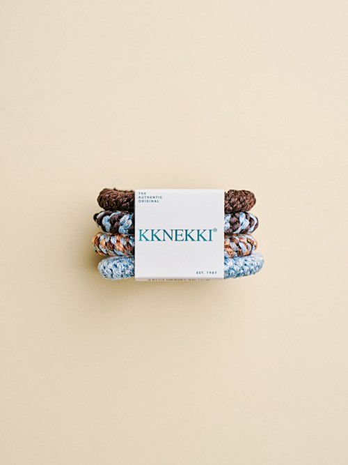 Stabel med tre mønstrede hårbånd med KKNEKKI-merke på en lys bakgrunn.