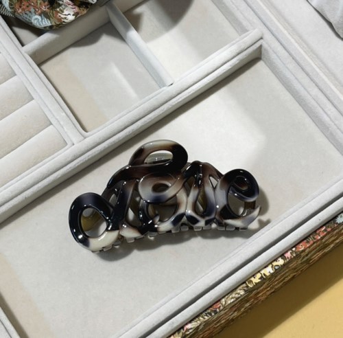A decorative item spelling the word "Love" in shiny, black and white marble-like material inside a jewelry box.