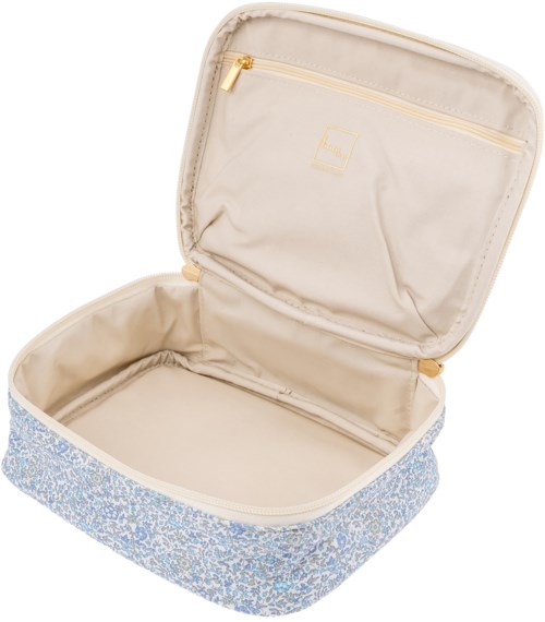 A small travel bag with a beige interior and a blue floral exterior, open showing one compartment and a zippered pocket.