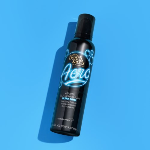 Czarna butelka spray z napisem 'Bondi Sands Aero' samoopalający piankowy spray, z niebieskim i białym tekstem, na niebieskim tle.