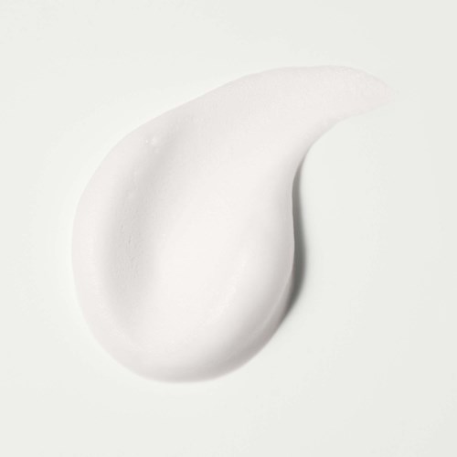 En klick med vit kräm eller lotion på en vit bakgrund.