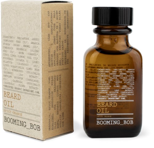 Eine kleine braune Flasche mit "Beard Oil" Beschriftung, mit würzigem Duft und einer separaten Box mit Inhaltsstoffen und Anweisungen.