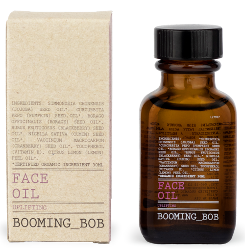 Eine kleine braune Flasche mit der Aufschrift 'Face Oil Uplifting' und eine einfache Pappschachtel mit Inhaltsstoffen und Markennamen 'Booming_Bob'.