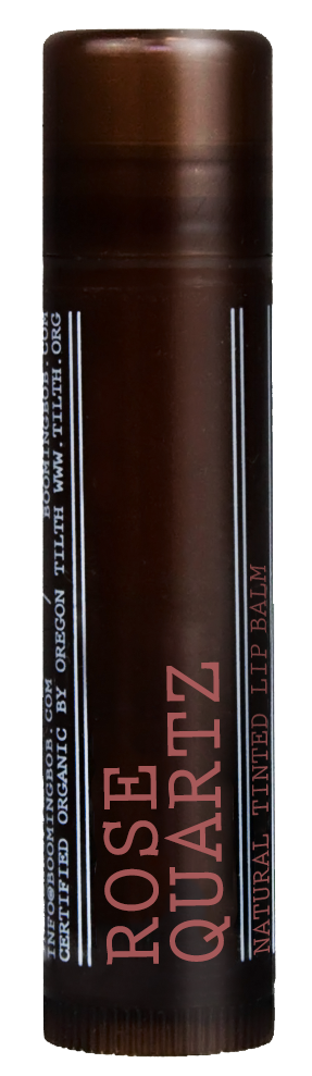 Ein brauner Stick mit pinken und weißen Worten, beschriftet 'Rose Quartz'. Es ist eine Lippenbalsamverpackung.