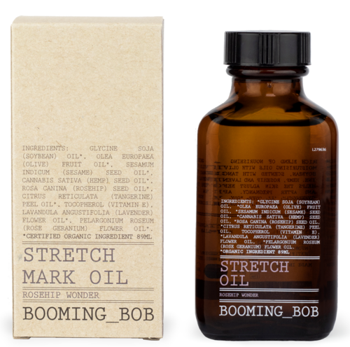 Eine braune Flasche und eine cremefarbene Box enthalten Stretch Mark Oil mit Hagebutte und anderen natürlichen Zutaten.