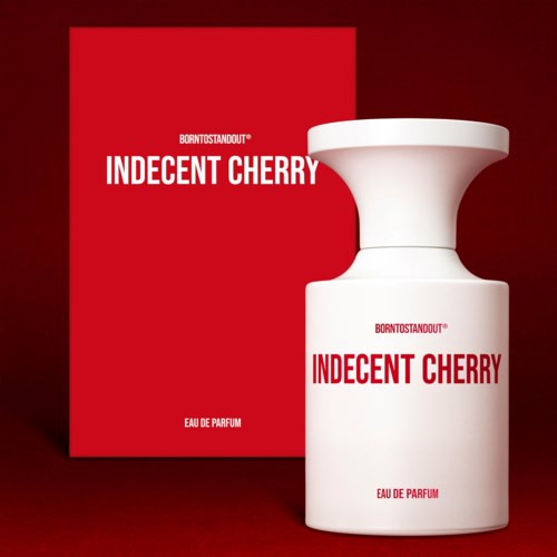 Rood doosje promoot 'Indecent Cherry' parfum met witte fles. Simpel, vetgedrukte tekst. Elegant en minimalistisch ontwerp.