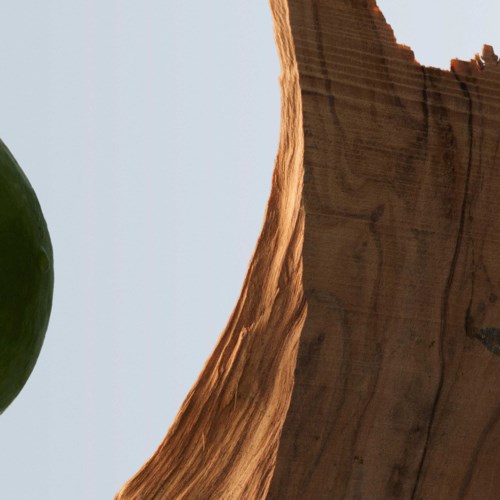 Een close-up van een groene appel en een houten oppervlak met een eenvoudige achtergrond.