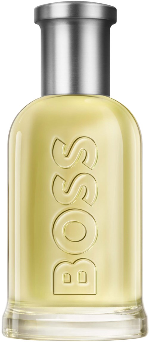 Een heldere glazen fles met gele vloeistof parfum en een zilveren dop, met de tekst "BOSS".
