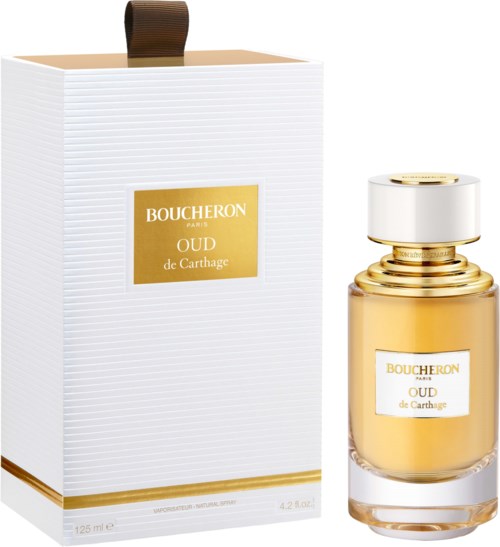 A perfume bottle and box are shown; the bottle is gold and clear with a white and gold cap.
