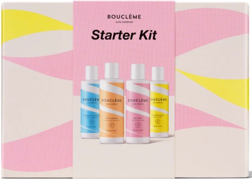 Vier flessen van Bouclème Startpakket met kleurrijke labels, geplaatst op een roze-witte achtergrond.